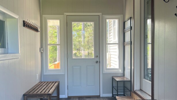 A hallway with a wooden bench, a door, and a small table. - M-28 House
Direct Trail Access - Ample Trailer Parking - Year-Round Fun (Marquette)