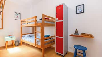 A bunk bed room with a red storage unit and a small desk with a chair.