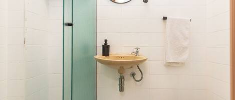 Une salle de bain équipée d’un lavabo, d’un miroir et d’un porte-serviettes.