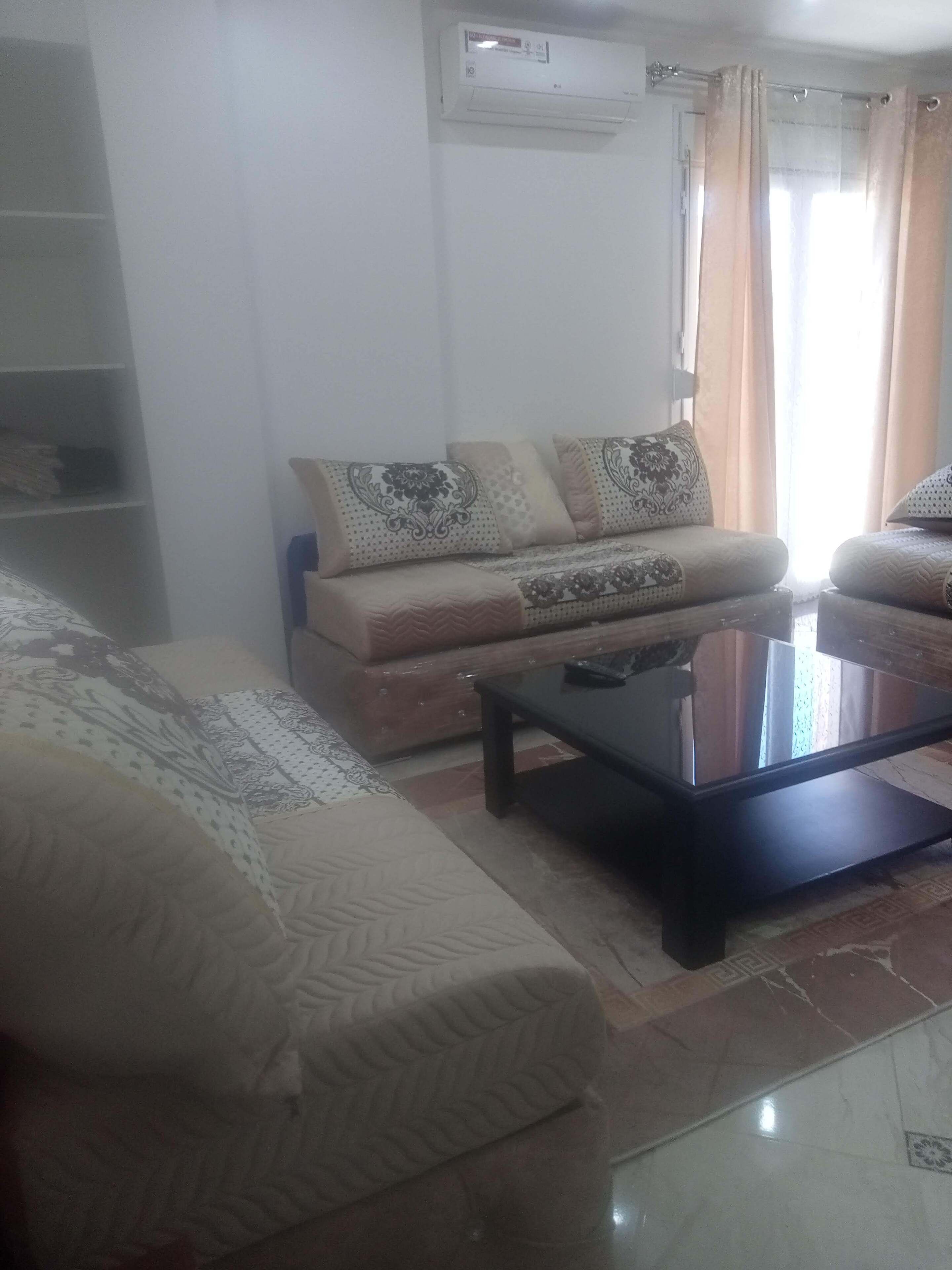 Un salon avec un canapé, une table basse et un téléviseur.