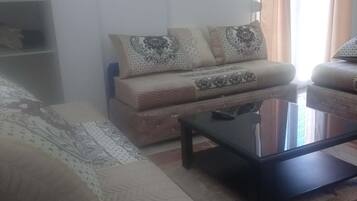 Un salon avec un canapé, une table basse et un téléviseur.