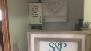 Una recepción con un letrero enmarcado que dice "S&P SESAMOS PANSIYON".