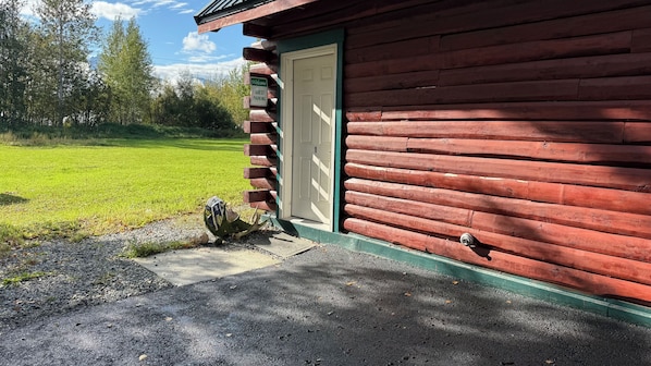 A red wooden building with a white door, a welcome sign, and a mailbox. - Beautiful Butte BNB 1-bedroom apartment in fantastic Palmer with WiFi. (Palmer)