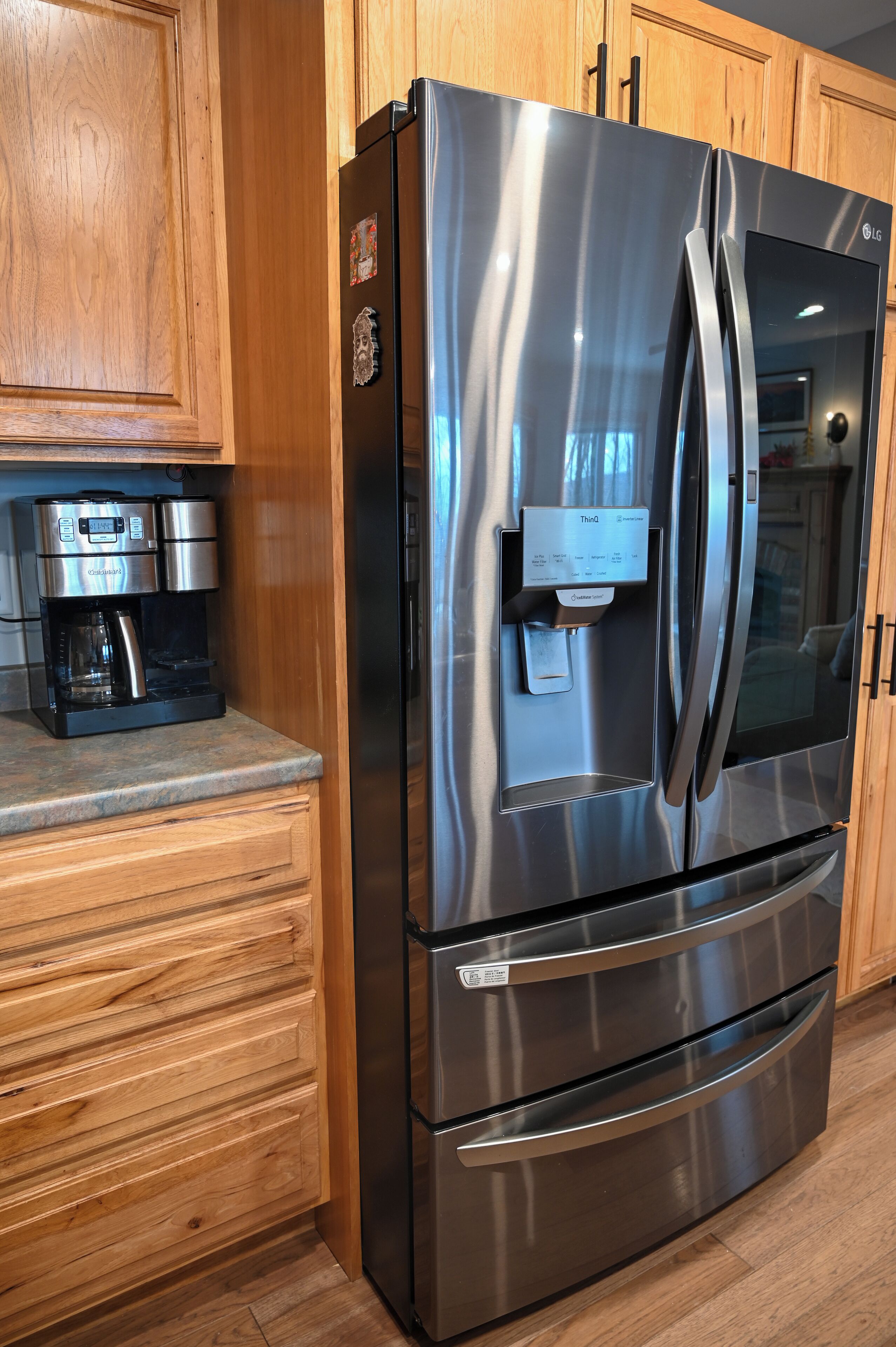 A stainless steel refrigerator with a built-in ice maker and a coffee maker on the countertop.
