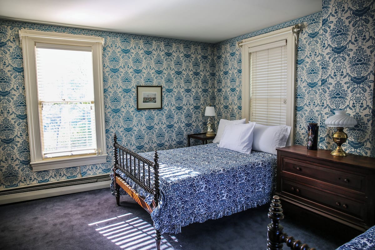Un dormitorio con cama, cómoda y ventana con persianas.