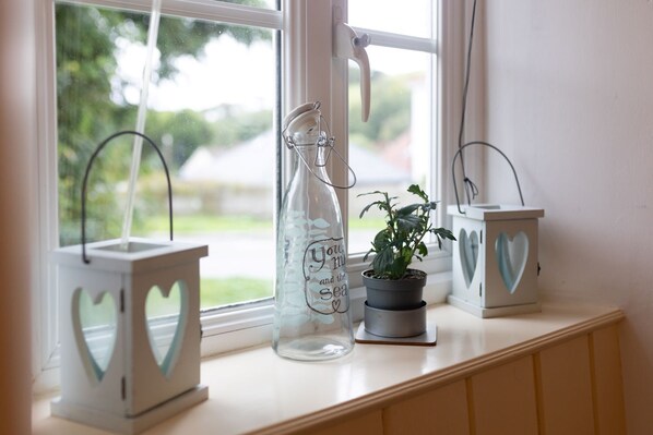 A window sill with three decorative lanterns, one with a heart-shaped cutout and another with a heart-shaped cutout and a plant. - A charming, pet-friendly 2 bedroom cottage (Braunton)