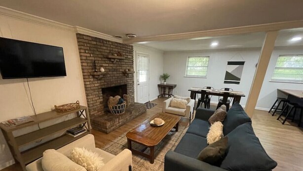 Un salón con chimenea, sofá, mesa de centro y televisor.