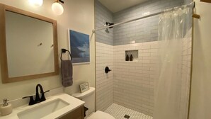 Une salle de bain avec un lavabo, des toilettes et une douche.