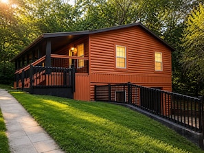 Een houten blokhut met een veranda en een omheinde tuin.