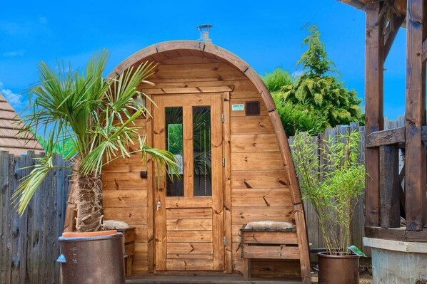 A wooden cabin with a curved roof, a front door, and a small bench.