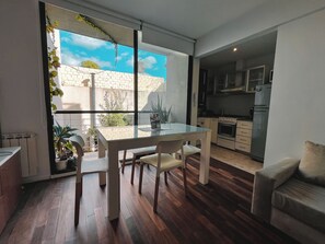 Une cuisine moderne dotée d’un four encastré et d’un coin repas avec une table et des chaises en verre.