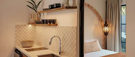 Una cocina moderna con un lavamanos, una encimera y un estante arriba.