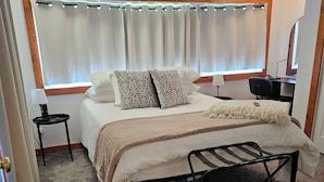 A bedroom with a bed, bedside tables, a desk, and a chair. - Thoughtfully Renovated 2BR Retreat|10 Miles to South Haven & Lake Michigan (Bangor)
