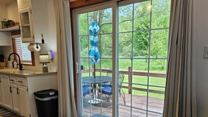 A kitchen with a window, a dining area with a table and chairs, and a view of a garden. - Thoughtfully Renovated 2BR Retreat|10 Miles to South Haven & Lake Michigan (Bangor)
