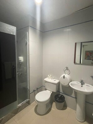 Un baño pequeño con inodoro, bidé y lavamanos.