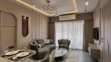 A modern living room with a sectional sofa, a coffee table, and a dining area with a set table.