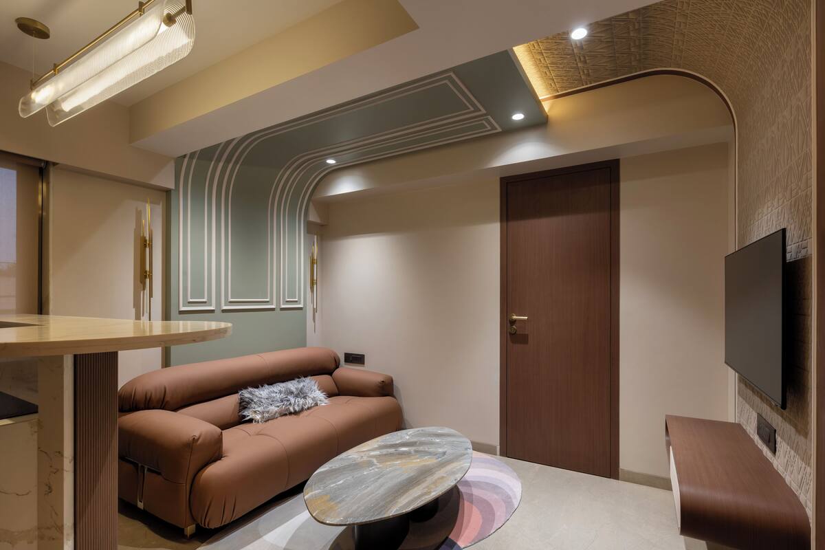 A modern living room with a brown sofa, a marble coffee table, and a flat-screen TV mounted on the wall.