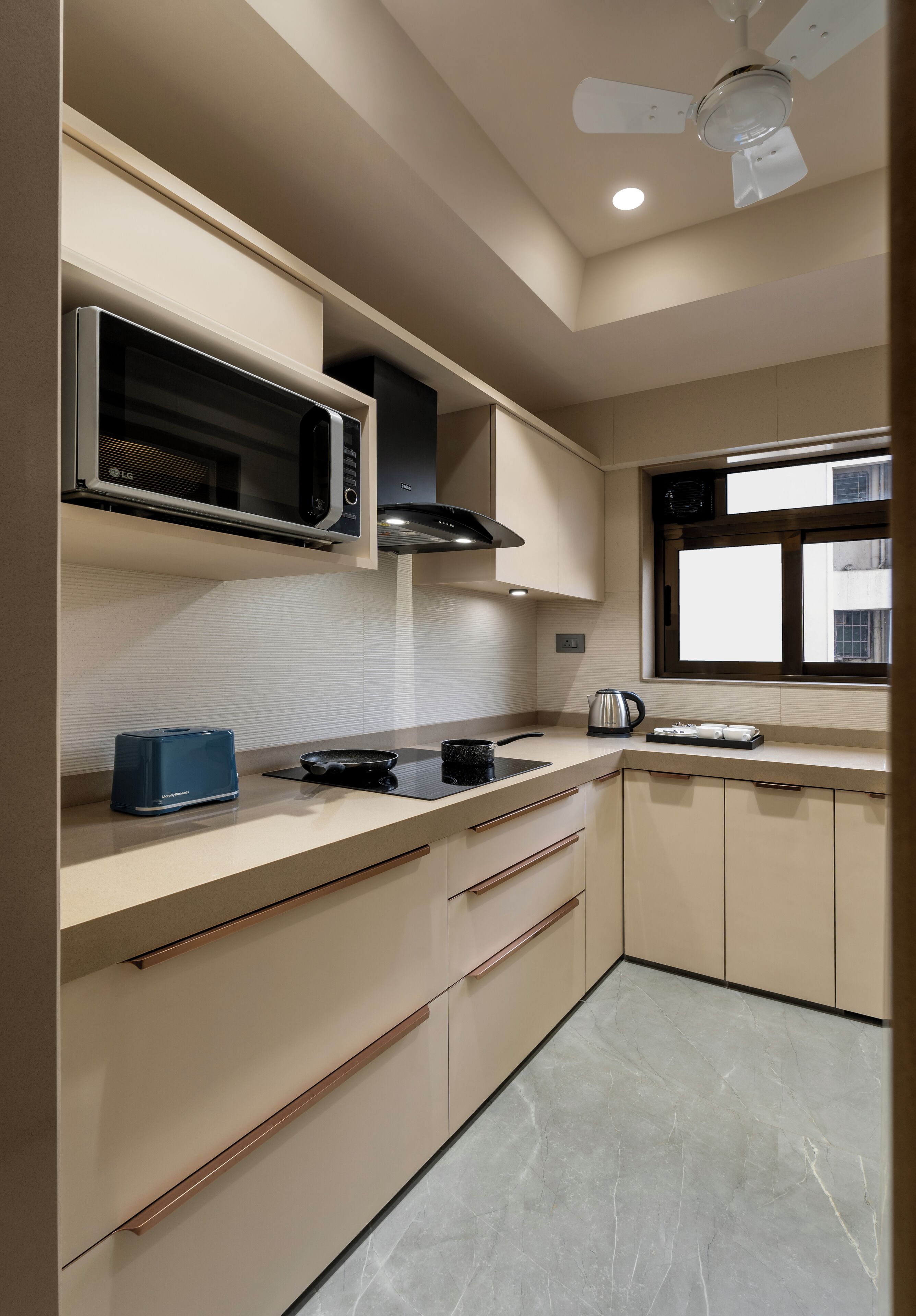 Una cocina moderna con microondas, tostadora, hervidor y ventana con vistas.