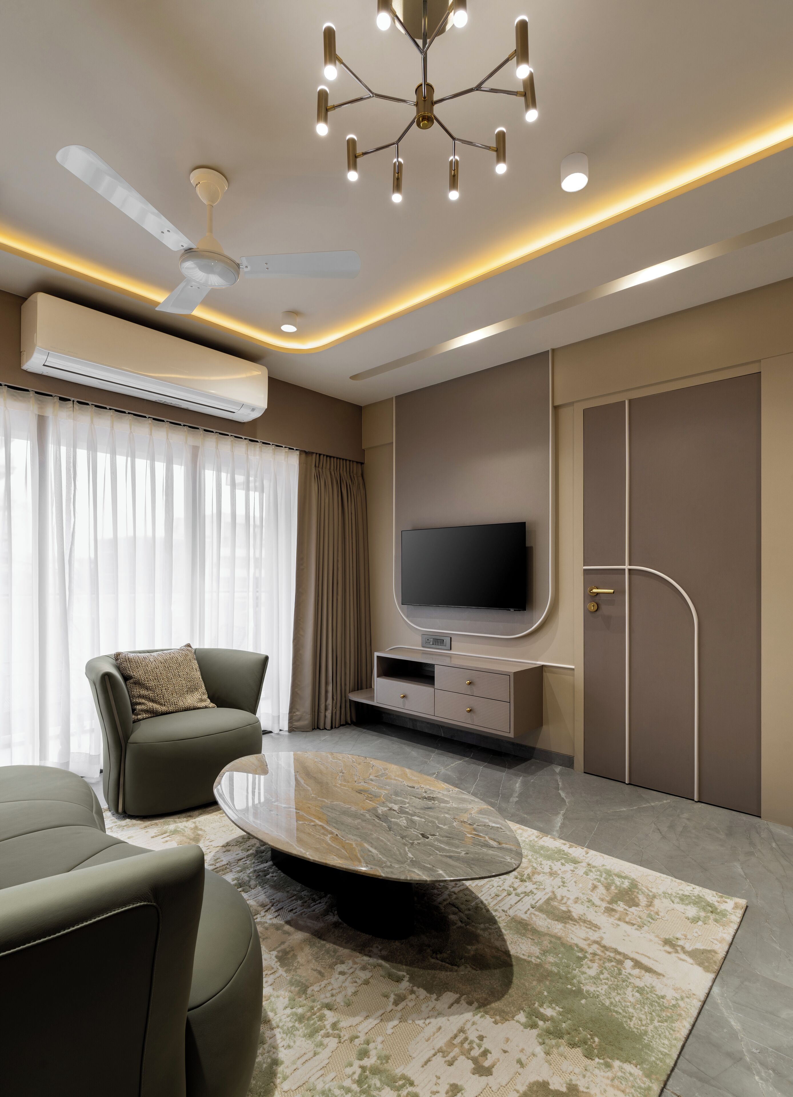 A modern living room with a flat-screen TV, a ceiling fan, and an air conditioning unit.