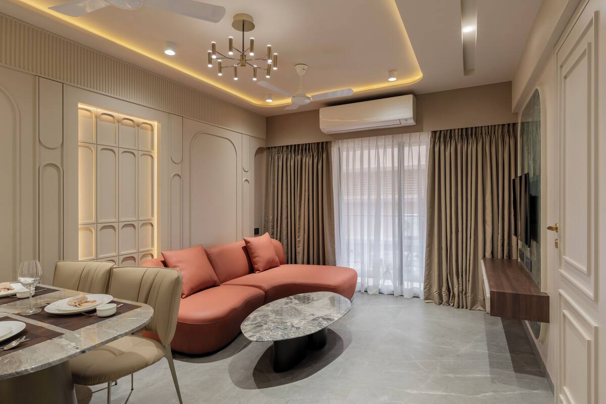 A modern living room with a sofa, a dining table, and a flat-screen TV.
