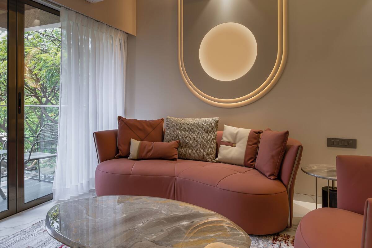 A modern living room with a sofa, a glass coffee table, and a ceiling fan.