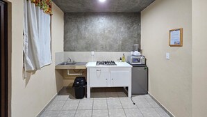 Una cocina compacta con lavabo, estufa y un refrigerador pequeño.