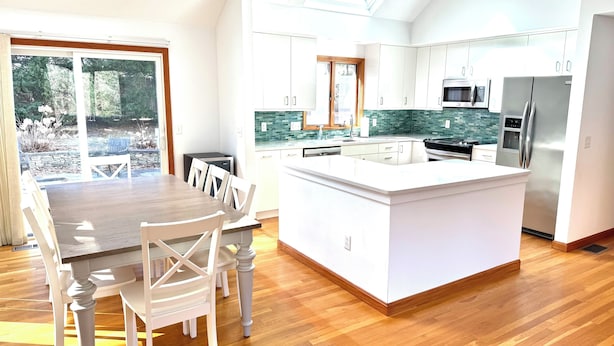 A modern kitchen with a central island, white cabinetry, and a skylight. - HarwichPort 4 bdr 3 bath - Walk to Red River Beach - next to Wychmere (Harwich)