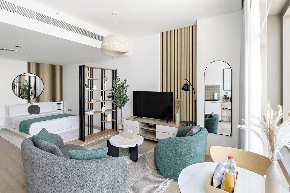A modern living room with a sofa, a coffee table, a TV, and a bookshelf.