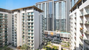 A high-rise residential building with multiple balconies, a rooftop pool, and a modern architectural design. - Silkhaus Sobha Hartland Greens (Dubai)