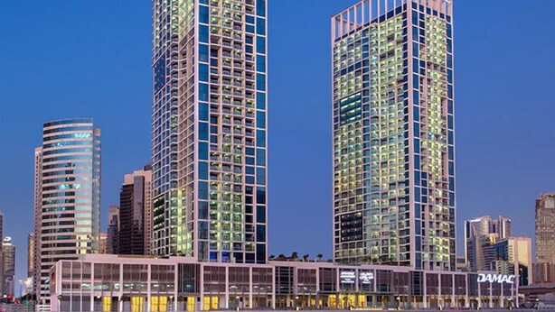 Two high-rise buildings with a glass facade, likely part of a hotel complex, with a waterfront view. - Silkhaus Damac Prive Tower (Dubai)