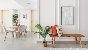 A modern living room with a dining area, a wooden bench, and a potted plant. - Silkhaus Oceanscape (Abu Dhabi)