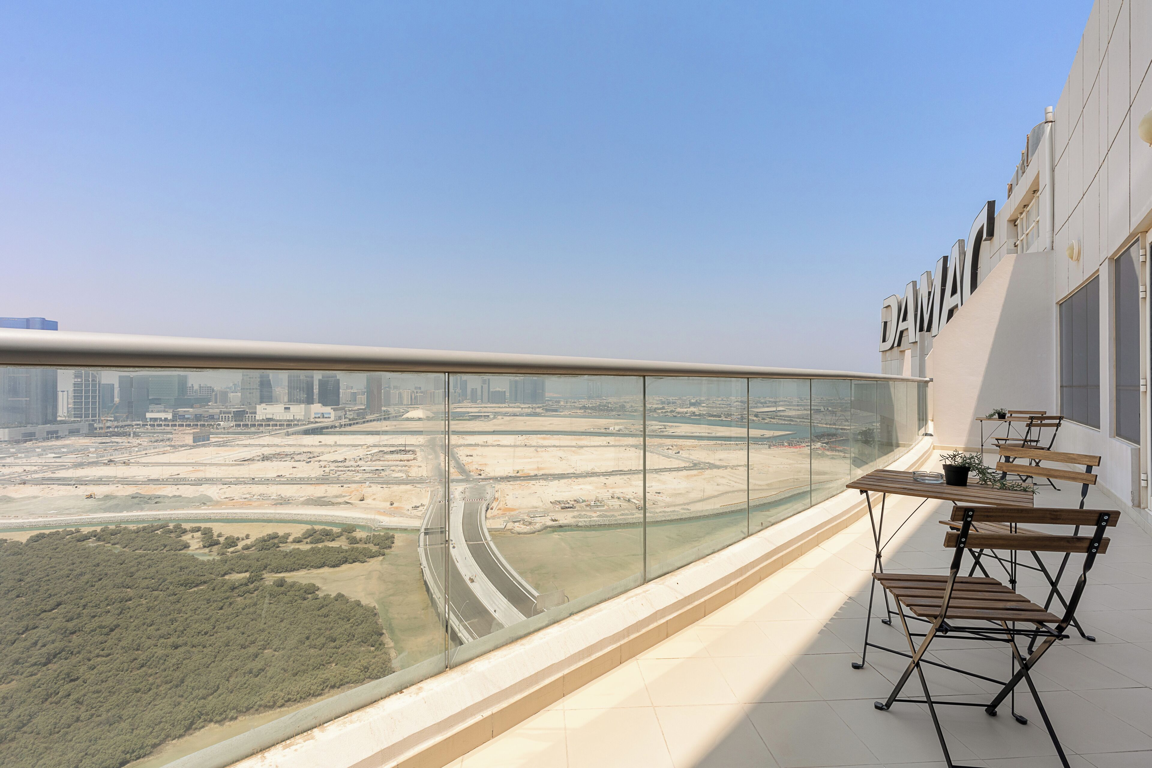 Ein Balkon mit Blick auf eine Stadtlandschaft, darunter eine Autobahn und Gebäude.