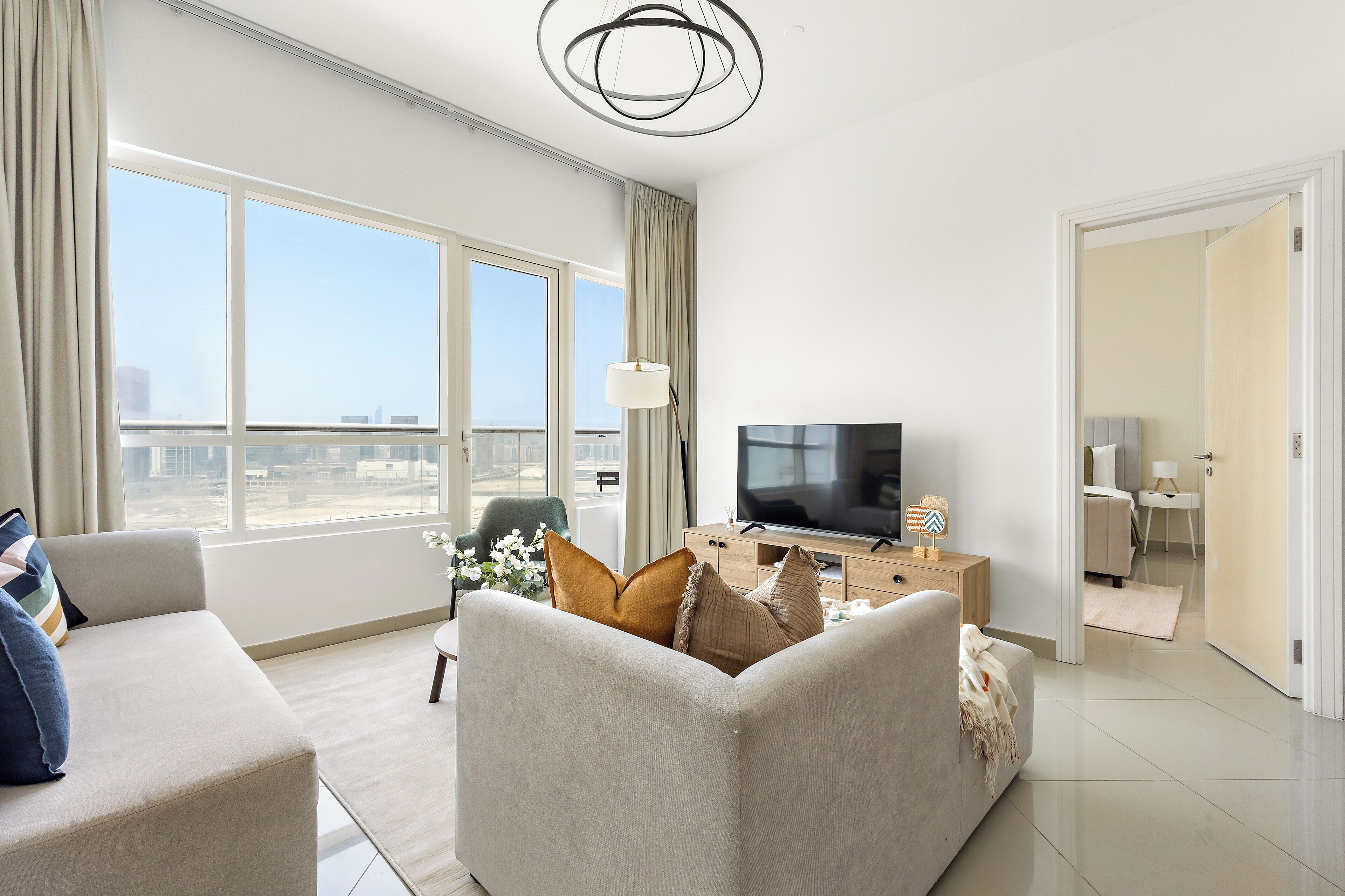 Un salon moderne avec un canapé, un téléviseur et une vue sur la ville.