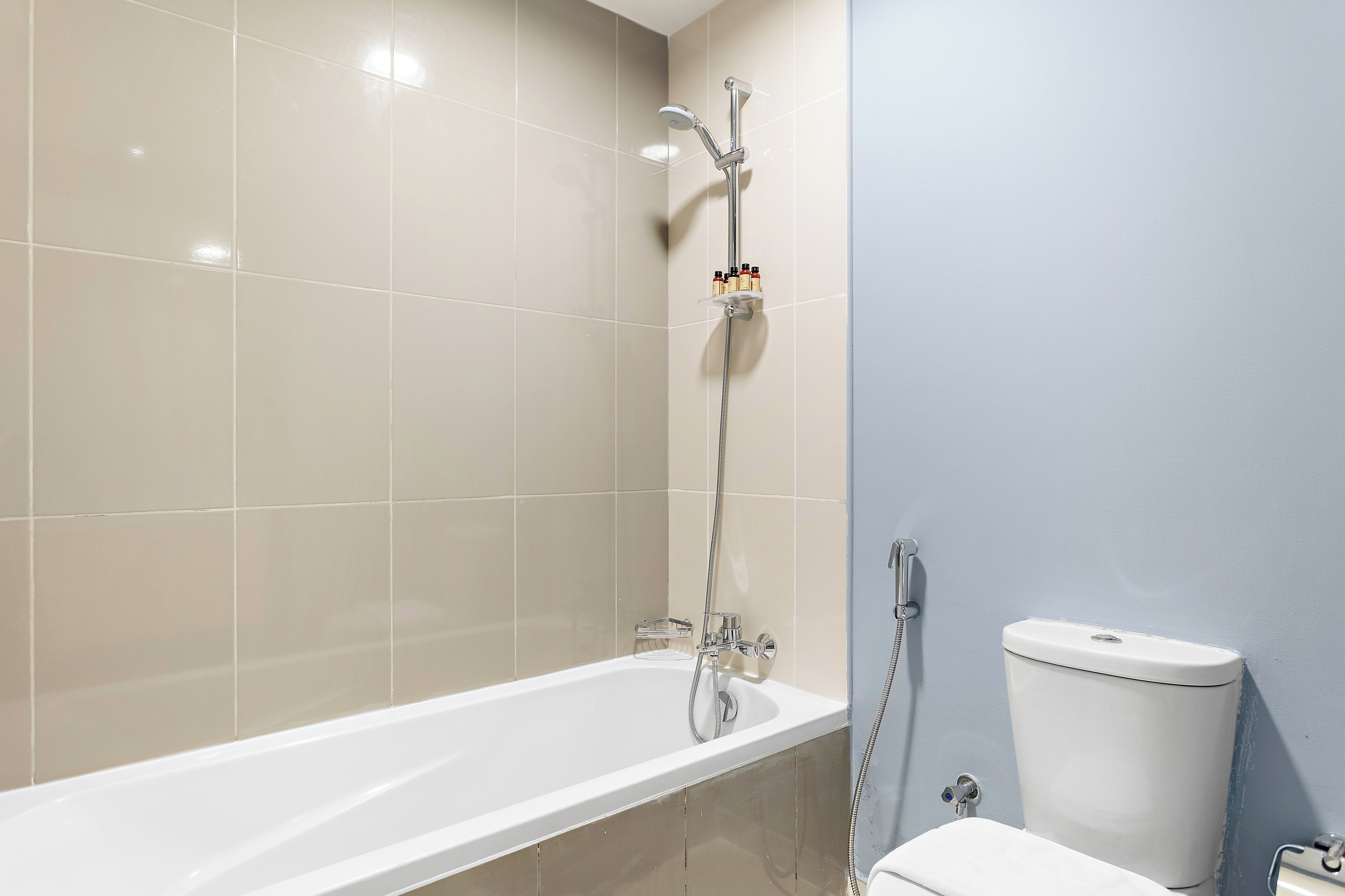 Et badeværelse med badekar, toilet og brusebad.