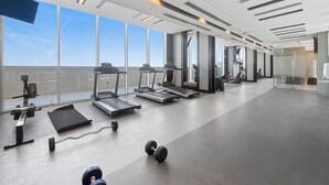 A modern gym with treadmills, weights, and exercise equipment.