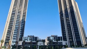 Two tall, modern buildings with a clear blue sky in the background.