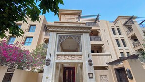 Un edificio con una entrada central que presenta un arco decorativo y una puerta de madera oscura.