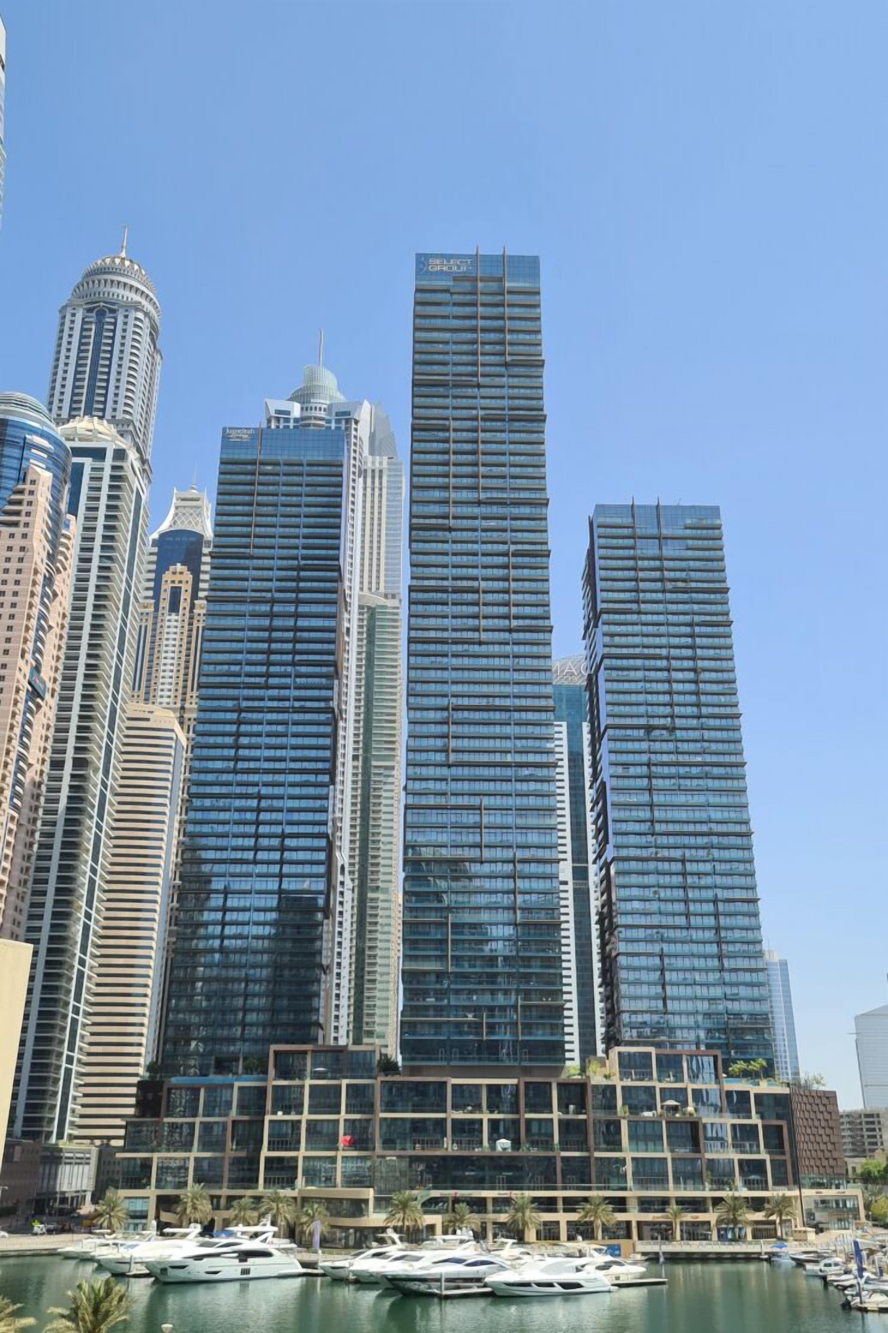 Eine moderne Skyline mit Wolkenkratzern und einem Hafen mit Booten.