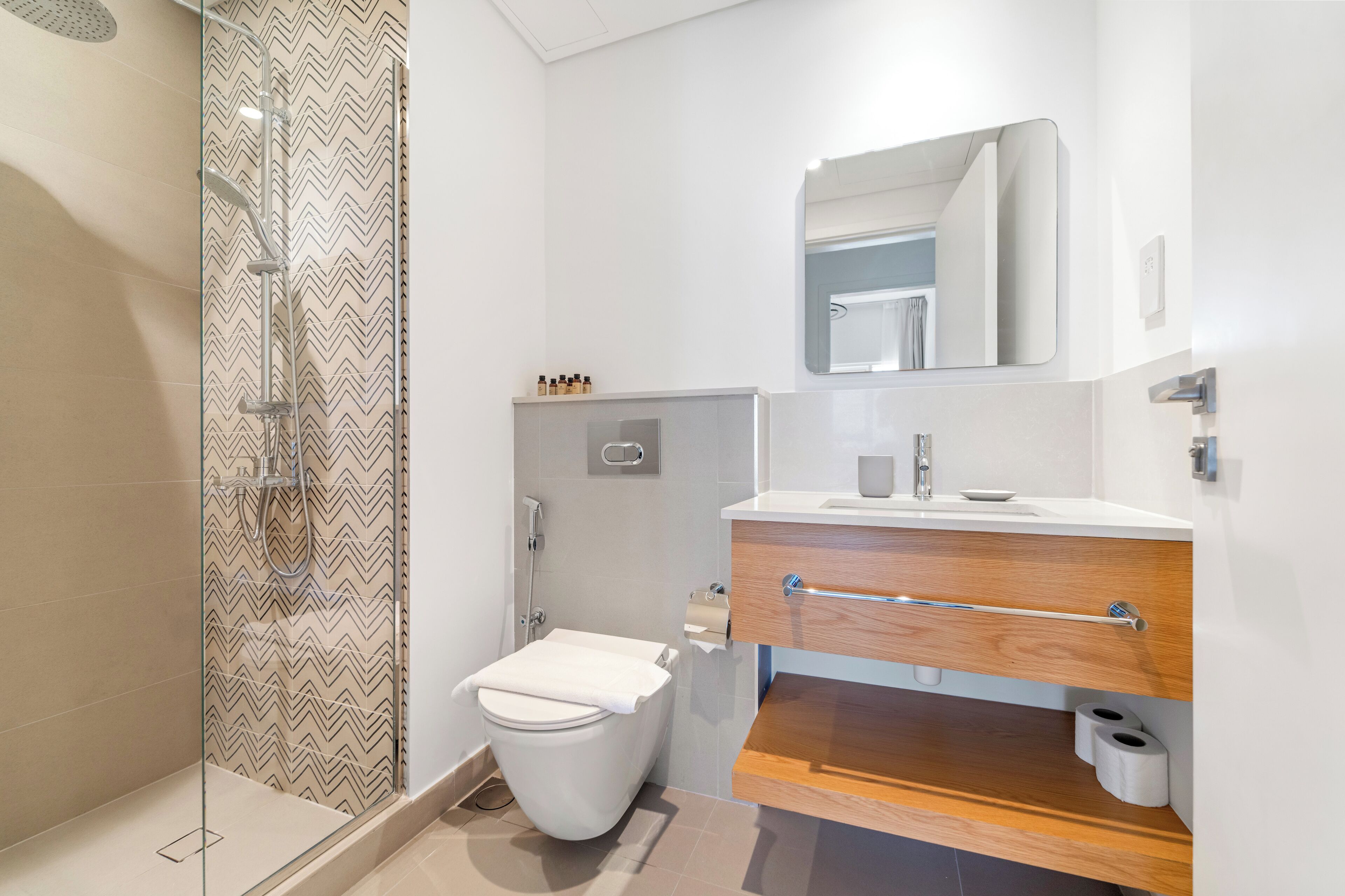 Un baño moderno con ducha, inodoro y tocador.