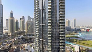 A high-rise building with multiple balconies, surrounded by other tall buildings and a construction site. - Silkhaus Act One Towers (Dubai)