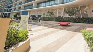 Un edificio moderno con facciata curva, numerosi balconi e cielo sereno.