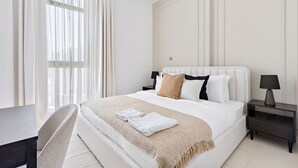 Une chambre d’hôtel avec un grand lit, un bureau et une chaise.