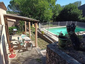 A backyard with a pool, a pergola, outdoor furniture, and a stone wall. - Self-contained studio at the gateway to the Cévennes (Boisset-et-Gaujac)