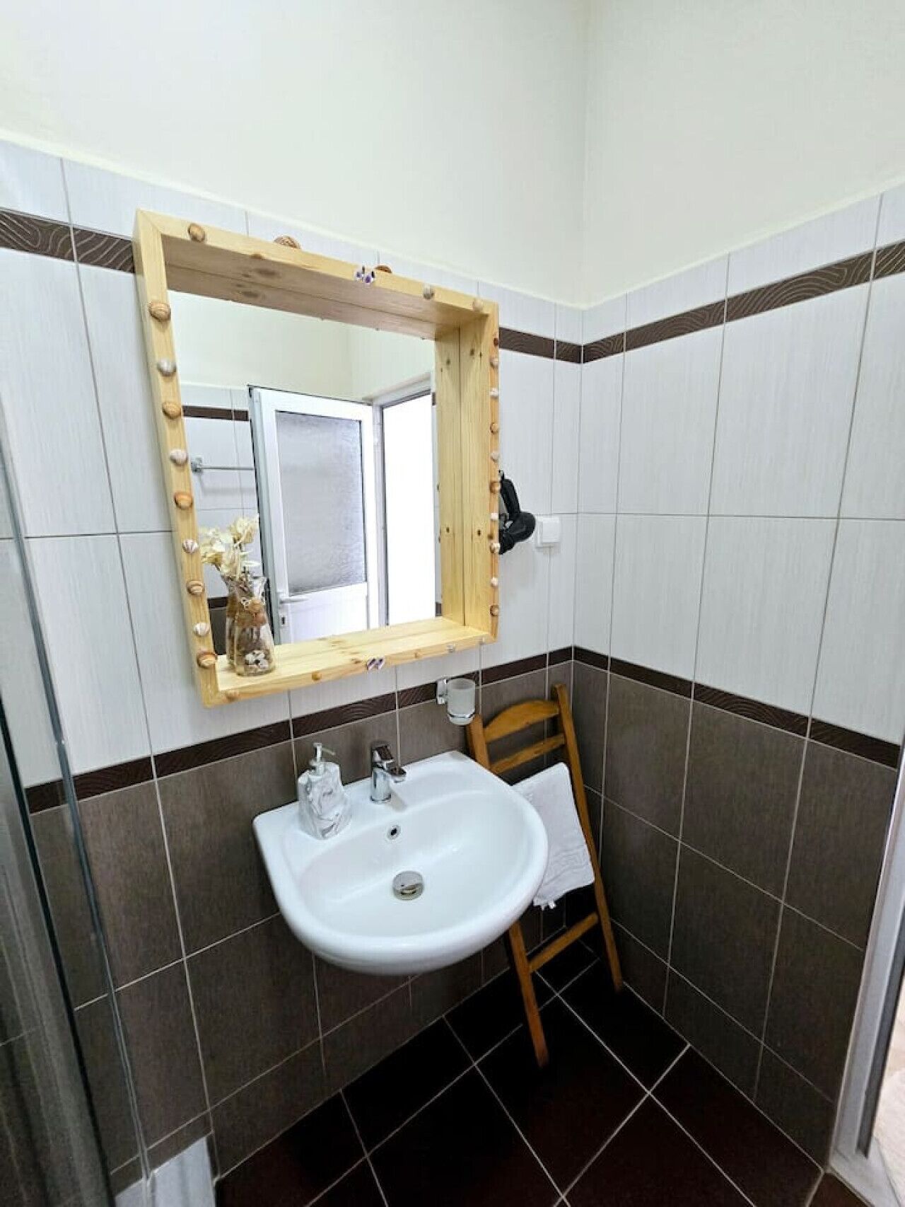 A bathroom with a white sink, a mirror with a wooden frame, and a towel rack.