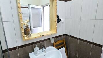 A bathroom with a white sink, a mirror with a wooden frame, and a towel rack.