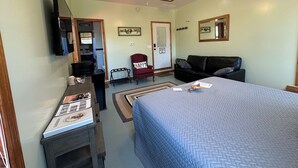 A bedroom with a bed, a desk, a chair, a sofa, a ceiling fan, and a door with an 'EXIT' sign. - Cozy B&B in walking distance to onsite tasting room in Lee! (Lee)