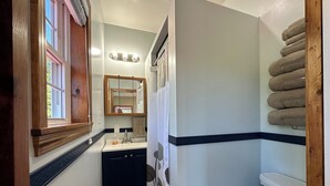 A bathroom with a window, a sink, a mirror, and a toilet. - Cozy B&B in walking distance to onsite tasting room in Lee! (Lee)