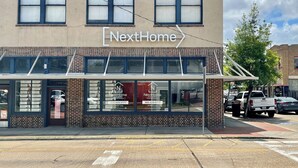 Un immeuble dont la façade porte une enseigne indiquant « NextHome ».