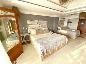 Un dormitorio con dos camas, cabecero de madera, un espejo y una mesita.