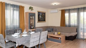 A dining area with a table set for four, a sofa, and a coffee table.